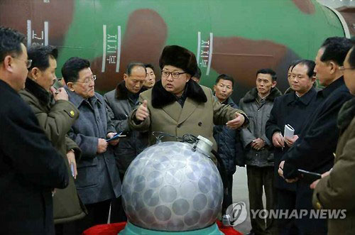 김정은이 핵무기 연구부문 과학자와 기술자들과 ‘핵탄두 기폭장치로 추정되는 물체’를 앞에 놓고 현지지도를 하고 있다. (2016년 3월)