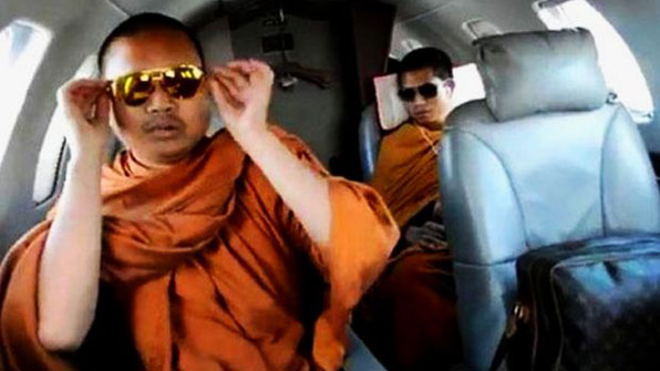 고가 선글래스를 낀 채 명품 가방을 들고 개인 전용 제트기로 해외 여행을 다닌 넨캄의 동영상 화면 캡처. 이 동영상이 유포되면서 태국에서는 넨캄에 대한 비난 여론이 빗발쳤다.