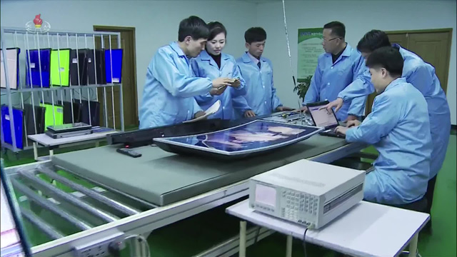 보통강 전자제품 공장에서 종업원들이 생산 중인 곡면 TV를 앞에 두고 이야기를 하고 있다.
