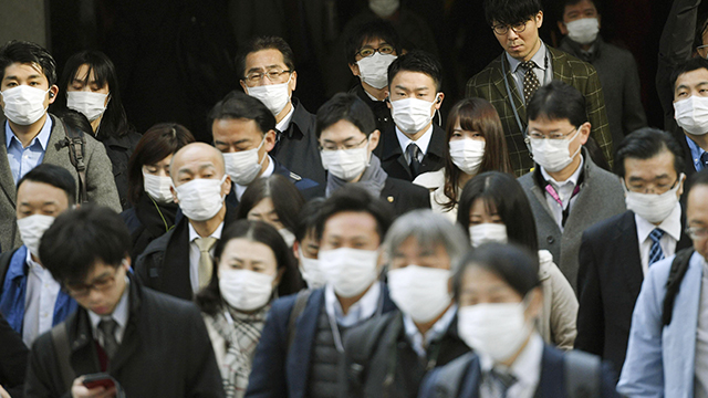 고이케 도쿄도지사가 ‘재택 근무’를 촉구한 직후인 지난달 26일 도쿄에서 마스크를 쓴 직장인들이 출근하고 있다. 〈교도=연합〉