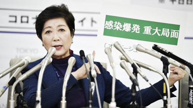 고이케 일본 도쿄도 지사가 25일 긴급 기자회견에서 ‘감염 폭발, 중대 국면’이라고 쓴 카드를 들어 보이고 있다. (교도=연합)