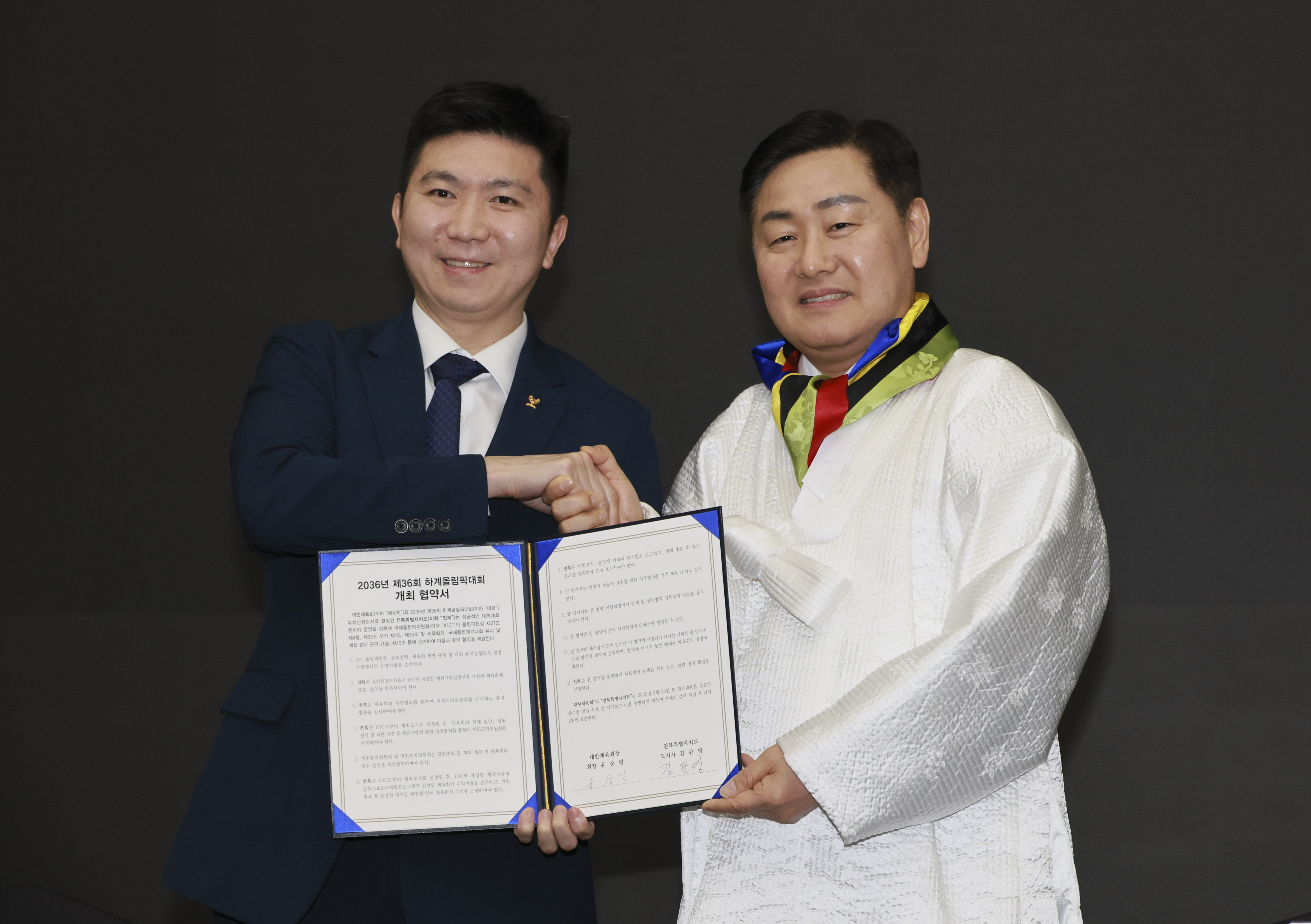 Korean Sport & Olympic Committee President Yoo Seung-min, a former IOC Athletes’ Commission member, and Jeonbuk Governor Kim Kwan-young shake hands after selecting Jeonbuk as the nation's candidate city for the Olympics.