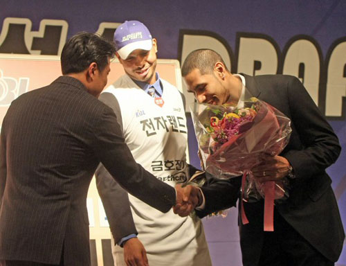 2010 KBL 귀화 혼혈선수 드래프트에서 '최대어'로 꼽힌 재로드 스티븐슨(35.한국 이름 문태종)이 3일 오후 서울 교육문화회관에서 열린 드래프트에서 전자랜드에 1차 지명되자 LG에서 뛰고 있는 동생 문태영이 단상에 올라 유도훈 감독에게 인사하고 있다.