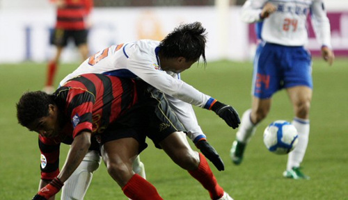 24일 경북 포항스틸야드에서 열린 2010 아시아축구연맹(AFC) 챔피언스리그 조별리그 포항 스틸러스-산둥 루넝(중국) 경기에서 포항의 알미르와 중국의 유안이 공을 다투다 몸이 엉키는 순간 공이 다른쪽으로 흐르고 있다.