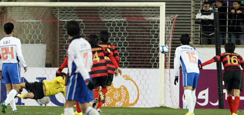 24일 경북 포항스틸야드에서 열린 2010 아시아축구연맹(AFC) 챔피언스리그 조별리그 포항 스틸러스-산둥 루넝(중국) 경기에서 포항의 골키퍼 신화용이 중국의 페널티킥을 막아내고 있다. 신화용의 손에 걸린 공이 골대 쪽으로 날아가자 선수들이 골을 주시하고 있다.