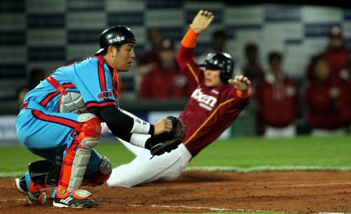 28일 부산 사직야구장에서 열린 2010 프로야구 롯데 자이언츠-넥센 히어로즈 경기,  넥센 김민우(오른쪽)가 3회초 1사 2루 상황에서 권도영의 안타 때 홈으로 들어오고 있다.