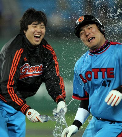 28일 부산 사직야구장에서 열린 2010 프로야구 롯데 자이언츠-넥센 히어로즈 경기, 롯데 강민호가 5대5 동점이던 9회말 2사 2루 상황에서 끝내기 안타를 친 후 팀 동료 투수 조정훈에게서 물세례를 받고 있다.