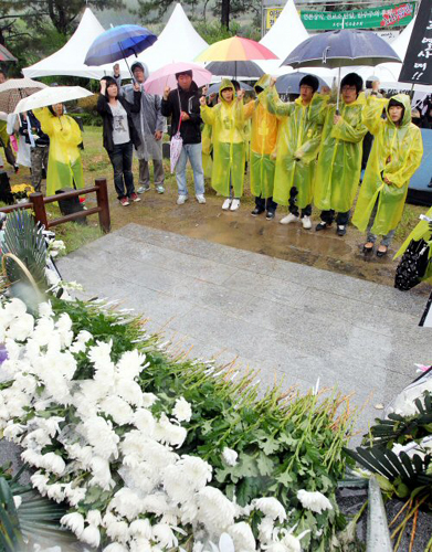 18일 오전 광주 북구 운정동 국립 5.18민주묘지에서 5.18 30주년 기념식이 열리고 있는 가운데 별도의 기념식이 치러지고 있는 5.18 구묘역에서 학생들이 '임을 위한 행진곡'을 부르고 있다.
