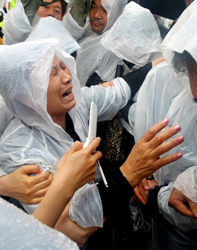 18일 오전 광주 북구 운정동 국립 5.18민주묘지에서 열린 제30주년 5.18 광주민주화운동 기념식에서 한 유족이 기념식에서 `임을 위한 행진곡'을 부르지 못하게 되자 이에 항의하기 위해 행사장에 들어와 항의하다 울부짖고 있다. 국가보훈처는 이날 `임을 위한 행진곡' 대신 `방아타령'을 연주해 5.18 단체가 구묘역에서 따로 행사를 개최하는 등 논란이 됐다.