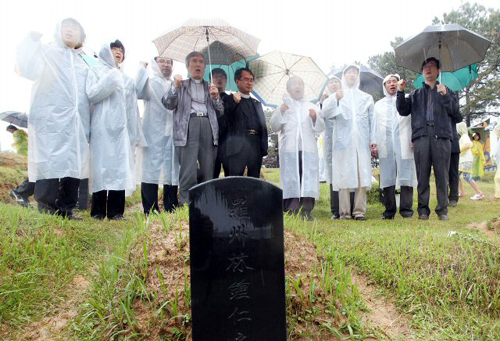 18일 오전 광주 북구 운정동 국립 5.18민주묘지에서 5.18 30주년 기념식이 열리고 있는 가운데 별도의 기념식이 치러지고 있는 5.18 구묘역에서 시민들이 '임을 위한 행진곡'을 부르고 있다.