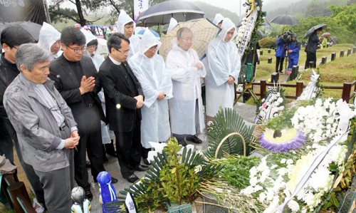 18일 오전 광주 북구 운정동 국립 5.18민주묘지에서 5.18 30주년 기념식이 열리고 있는 가운데 별도의 기념식이 치러지고 있는 5.18 구묘역에서 시민들이 오월 영령들을 추모하고 있다.
