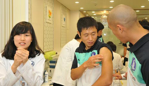 연세대 강남세브란스병원 내분비당뇨병센터팀이 지난 17일 파주 국가대표축구 트레이닝센터(NFC) 의무실을 찾아 축구국가대표 선수단에게 신종인플루엔자A(H1N1)에 대한 항체 생성률 검사를 기초로 예방접종을 실시하고 있다. 이영표와 차두리가 신종플루 백신을 접종 받기 위해 준비하고 있다.