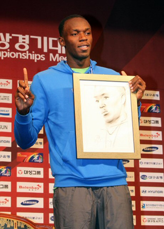 2010대구국제육상경기대회 100ｍ 종목에 출전하는 '인간 탄환' 우사인 볼트가 18일 오후 대구 수성구 만촌동 호텔인터불고에서 기자회견을 마친 뒤 자신을 그린 캐리커처를 받고 포즈를 취하고 있다. 대회는 19일 대구스타디움에서 열린다.