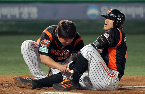 14일 오후 목동구장에서 열린 2010프로야구 넥센 히어로즈와 롯데 자이언츠 경기 8회초 2사, 롯데 홍성흔이 자신의 타구에 발목을 맞은 뒤 치료를 받고 있다.