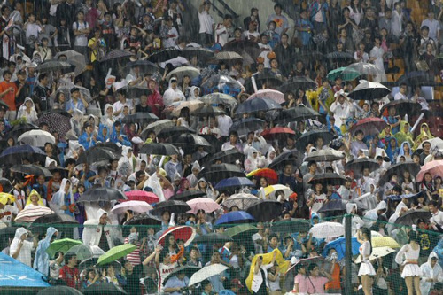 9일 오후 잠실야구장에서 열린 2010 프로야구 LG와 롯데의 경기중 폭우가 쏟아지자 관중들이 우산을 쓰고 열띤 응원을 하고 있다.