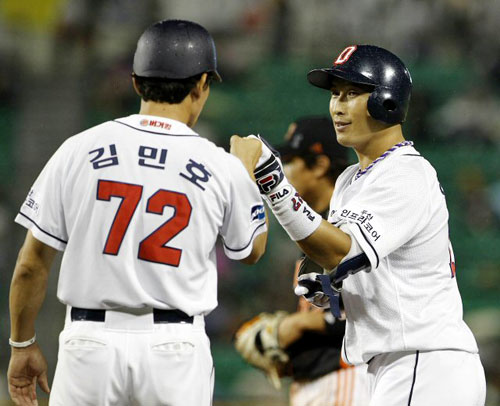 12일 오후 잠실야구장에서 열린 프로야구 롯데-두산 경기. 8회말 1사 만루 두산 임재철이 2타점 안타를 친뒤 1루 코치의 축하를 받고 있다.