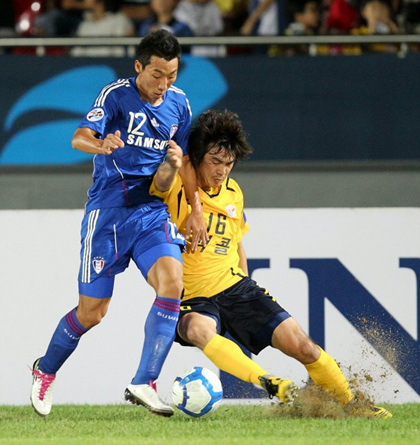 15일 성남 탄천종합운동장에서 벌어진 2010 아시아축구연맹(AFC) 챔피언스리그 8강 1차전 수원 삼성과 성남 일화의 경기에서 성남 김성환(오른쪽)과 수원 이현진이 볼 다툼을 벌이는 도중 잔디 밑 흙이 튀기고 있다. 성남 4대1 승.