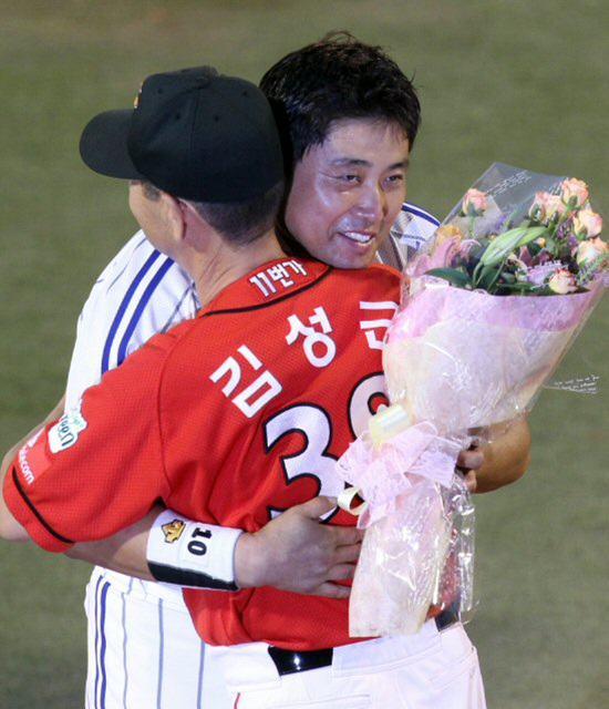19일 대구 시민운동장에서 열린 프로야구 삼성-SK 경기에서 5회말이 끝나고 열린 양준혁 은퇴식에서 SK 김성근 감독이 양준혁에게 꽃다발을 전달한 뒤 포옹하고 있다.