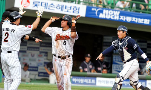 2일 오후 부산 사직야구장에서 열린 준플레이오프 3차전 롯데 대 두산 경기. 5회말 롯 데공격 무사 1,3루 손아섭 우익수 희생플라이 때 황재균이 홈에서 세이프된 후 조성환과 손바닥을 부딪치고 있다.