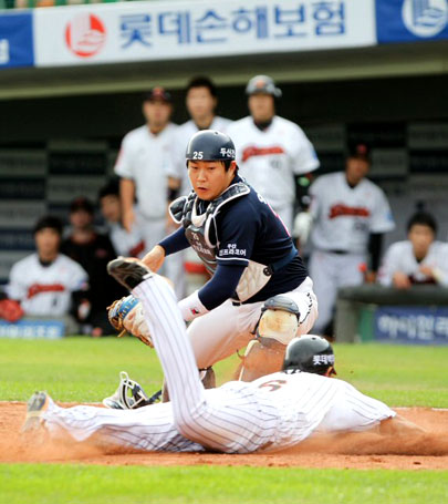 2일 부산 사직구장에서 열린 2010 프로야구 준플레이오프 두산 베어스-롯데 자이언츠 3차전. 4회말 무사 1.3루에서 롯데 손아섭의 외야플라이 때 3루주자 황재균(아래)이 홈에서 세이프되고 있다. 두산 포수는 양의지.