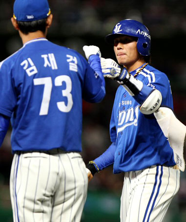 15일 인천 문학경기장에서 열린 2010 프로야구 한국시리즈 1차전 SK와 삼성 경기. 4회초 선두타자로 나서 우익수 앞 1루타를 때려낸 삼성 김상수가 김재걸 코치와 주먹을 맞대고 있다.