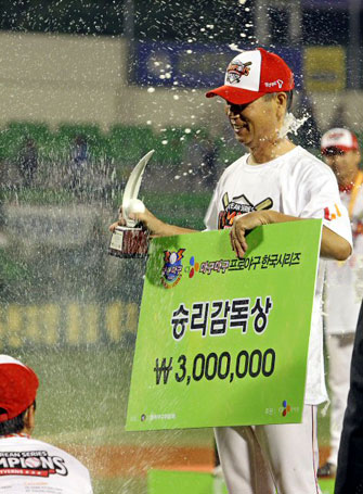 19일 대구시민운동장에서 열린 프로야구 한국시리즈 4차전에서 삼성 라이온즈를 꺾고 우승한 SK 와이번스 김성근 감독이 감독상을 받은 뒤 선수들의 샴페인 세례를 받고 있다.