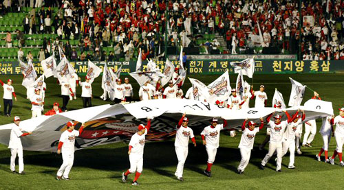 19일 오후 대구 시민운동장에서 열린 2010 프로야구 한국시리즈 4차전 삼성-SK 경기. 우승한 SK 김성근 감독과 선수들이 팀 대형 깃발을 들고 그라운드를 돌고 있다.