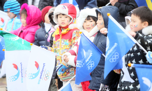 17일 강원 평창군 진부면 일대에서 어린이들이 현지실사에 나선 IOC 조사평가위원을 태운 버스가 오기를 기다리고 있다.