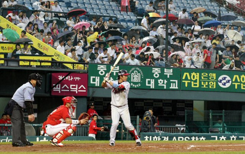 13일 오후 서울 잠실야구장에서 열린 SK-LG 프로야구 경기, 비가 내리기 시작하자 관중들이 우산을 펴고 경기를 보고 있다.