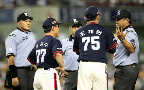 21일 오후 서울 잠실야구장에서 열린 프로야구 롯데와 두산의 경기. 6회말 2사 만루 상황에서 두산 3루주자 이종욱이 홈으로 달리다 롯데 3루수 황재균에게 태그아웃 당하자 두산 김광수 감독대행과 조계현 코치가 마운드에 올라가 심판에게 항의하고 있다.