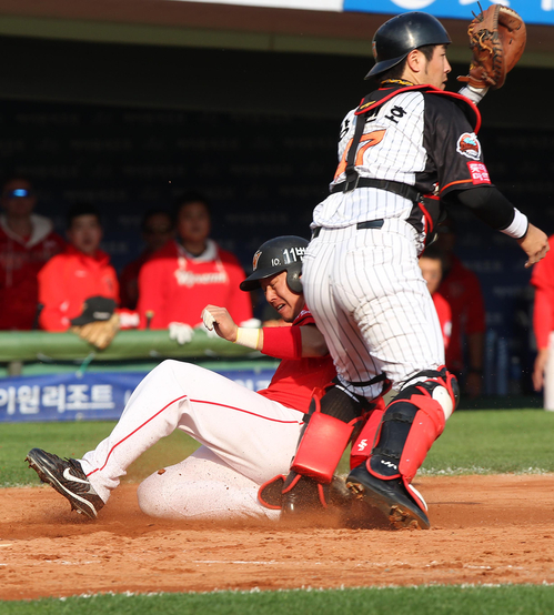 16일 부산 사직야구장에서 열린 2011 프로야구 플레이오프 1차전 롯데 자이언츠와 SK 와이번스의 경기 4회초 1사 만루 상황에서 타석에 들어선 SK 박진만의 플라이 타구에 3루 주자 안치용이 홈으로 들어오고 있다.