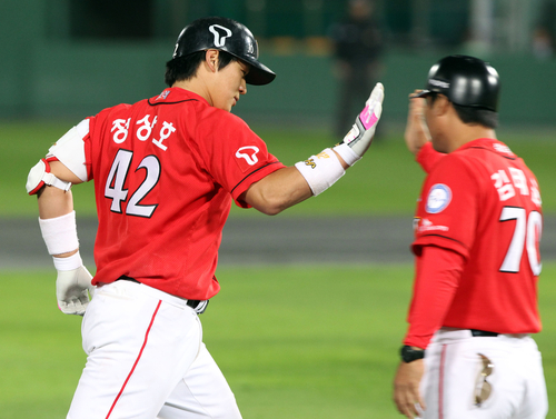 16일 부산 사직야구장에서 열린 2011 프로야구 플레이오프 1차전 롯데 자이언츠와 SK 와이번스의 경기. 10회초 무사에서 선두타자로 나온 SK 정상호가 롯데 투수 부첵을 상대로 역전 결승 솔로홈런을 때리고 3루코치와 하이파이브하고 있다.