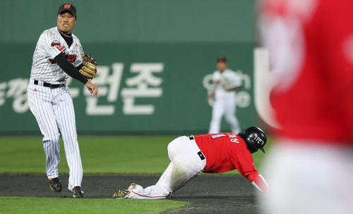 17일 부산 사직야구장에서 열린 2011 프로야구 플레이오프 2차전 롯데 자이언츠와 SK 와이번스의 경기 4회초 1사 주자 1루 상황에서 SK 박재상이 2루에서 아웃된 후 롯데 조성환이 1루로 송구하고 있다.