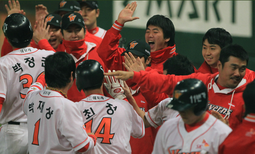 19일 인천 문학경기장에서 열린 2011 프로야구 플레이오프 3차전 SK 와이번스와 롯데 자이언츠의 경기. 8회말 SK 공격 2사 만루에서 최정과 박정권이 김강민의 좌중간 적시타로 득점한 후 동료들의 환영을 받고 있다. SK가 3-0으로 리드.