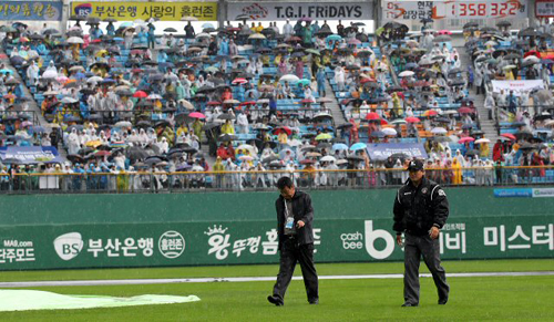 22일 부산 사직야구장에서 열릴 예정이었던 2011 프로야구 플레이오프 5차전 롯데 자이언츠-SK 와이번스 경기가 비로 취소됐다. 경기 관계자들이 취소 직전 그라운드 상태를 살피고 있다.