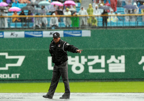 22일 부산 사직야구장에서 열릴 예정이었던 2011 프로야구 플레이오프 5차전 롯데 자이언츠-SK 와이번스 경기가 비로 취소됐다. 심판이 취소 직전 그라운드 상태를 살피고 있다.