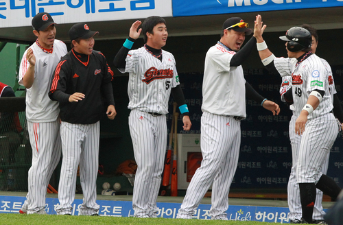 23일 부산 사직야구장에서 열린 2011 프로야구 플레이오프 5차전 롯데 자이언츠와 SK 와이번스의 경기. 6회초 무사 2,3루 롯데 강민호의 2루타 때 홈인한 홍성흔이 송승준과 하이파이브하고 있다.