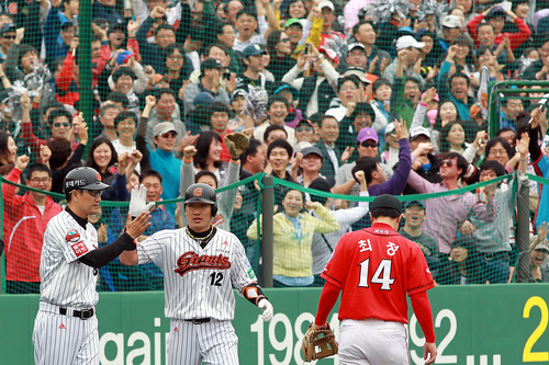 23일 부산 사직야구장에서 열린 2011 프로야구 플레이오프 5차전 롯데 자이언츠와 SK 와이번스의 경기. 1회말 무사 상황에서 김주찬이 3루타를 친 뒤 코치와 하이파이브하고 있다.