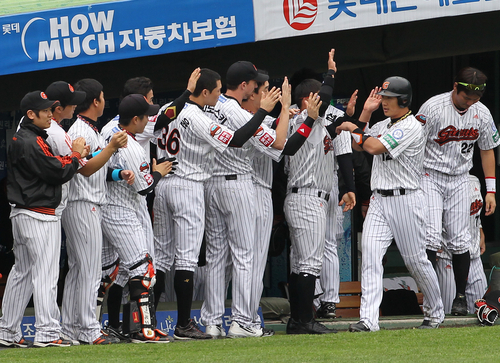 23일 부산 사직야구장에서 열린 2011 프로야구 플레이오프 5차전 롯데 자이언츠와 SK 와이번스의 경기. 1회말 선두타자로 나와 3루타를 친 롯데 김주찬이 전준우의 2루타 때 득점한 뒤 동료들과 하이파이브하고 있다.