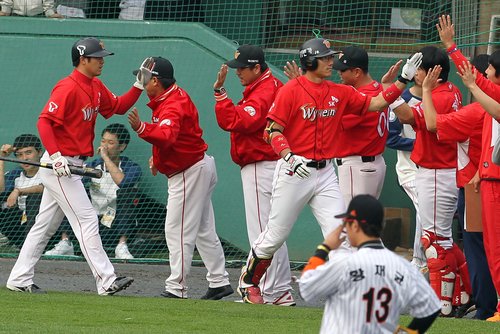 23일 부산 사직야구장에서 열린 2011 프로야구 플레이오프 5차전 롯데 자이언츠와 SK 와이번스의 경기. 4회초 1사 1루에서 SK 4번 박정권이 롯데 송승준을 상대로 역전 2점 홈런을 때리고 동료들과 하이파이브하고 있다.