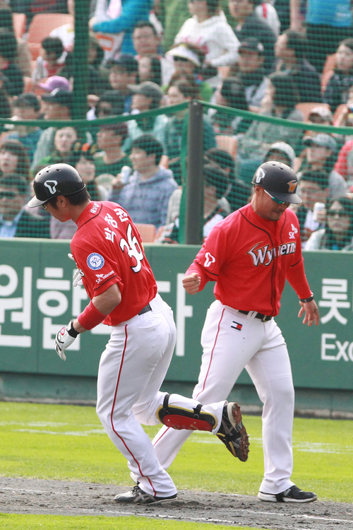 23일 부산 사직야구장에서 열린 2011 프로야구 플레이오프 5차전 롯데 자이언츠와 SK 와이번스의 경기. 6회초 무사 1루에서 SK박정권이 연타석 투런홈런을 때린 뒤 3루 코치와 하이파이브하고 있다.