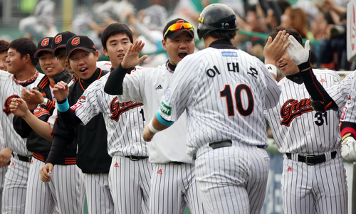 23일 부산 사직야구장에서 열린 2011 프로야구 플레이오프 5차전 롯데 자이언츠와 SK 와이번스의 경기. 6회말 무사 2,3루에서 롯데 강민호의 2타점 적시타로 홈인한 이대호가 동료들의 축하를 받고 있다.