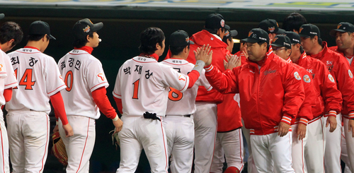 28일 오후 인천 문학구장에서 열린 프로야구 한국시리즈 3차전 SK와 삼성의 경기에서 SK가 2-1로 승리했다. 이만수 대행등 코칭스탭이 선수들과 손을 마주치며 승리를 기뻐하고 있다.