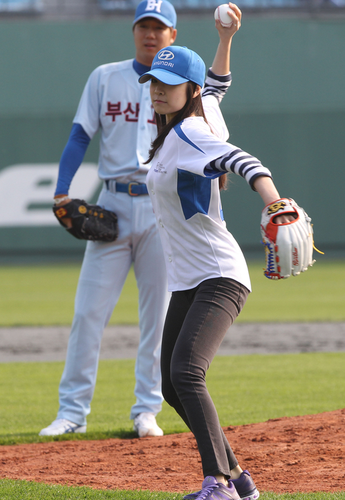 13일 부산 사직야구장에서 열린 '경남고-부산고 출신 라이벌 빅매치'에서 피겨 여왕 김연아가 시구하고 있다. 이날 행사에는 부산 야구 명문인 부산고와 경남고 출신 프로야구 현역 선수 50명과 은퇴 선수 30여명이 참가했다. 뒤편은 부산고 선발 장원준.