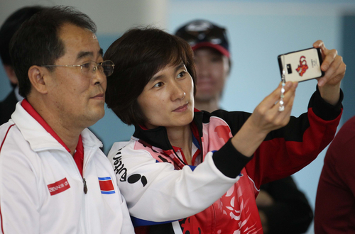 국제탁구연맹(ITTF)의 국제 탁구친선전 '피스 앤 스포츠컵'에서 함께 경기를 지휘할 한국 현정화 감독과 북한 리정식 감독이 21일 카타르 도하 알 야르묵 중학교 방문행사에서 스마트폰으로 셀카를 촬영하고 있다.