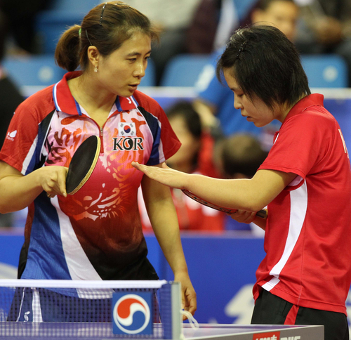 한국 김경아 선수가 21일 카타르 도하에서 열린국제탁구연맹(ITTF)의 국제 탁구친선전 '피스 앤드 스포츠컵'에서 긴장한 북한 김혜성 선수를 위로하고 있다. ITTF와 국제 스포츠 평화교류 비정부기구인 '평화와 스포츠(Peace and Sports)' 공동 개최로 남북한 등 모두 10개국이 참가하는 이번 대회에서 한국은 앞서 발표된 복식조 초안 그대로 북한과 한 팀으로 묶였다. 
    이에 따라 한국의 유승민(삼성생명), 김경아(대한항공)은 각각 북한의 김혁봉, 김혜성과 호흡을 맞춰 남녀 복식 토너먼트를 치르게 됐다.