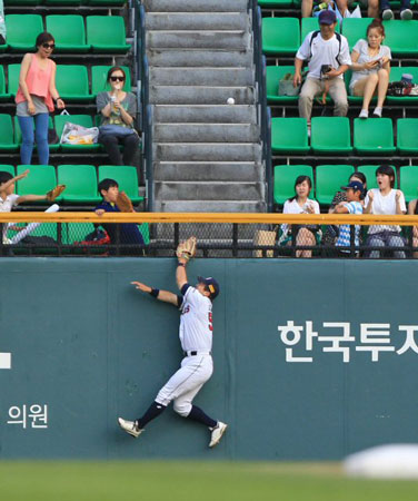 19일 서울 잠실구장에서 열린 2012 프로야구 두산 베어스-넥센 히어로즈 경기, 두산 좌익수 김현수가 1회초 2사 1루 상황에서 넥센 4번 타자 박병호의 2루타를 잡으려다 펜스에 부딪히고 있다.