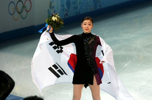 피겨여왕 김연아가 21일 오전 (한국시간) 러시아 소치 아이스버그 스케이팅 팰리스에서 열린 2014 소치 동계올림픽 피겨스케이팅 여자 싱글에서 러시아 아델리나 소트니코바에 이어 은메달을 획득했다. 김연아가 플라워세리머니를 마친 뒤 태극기를 몸에 감고 관중에게 인사하고 있다.