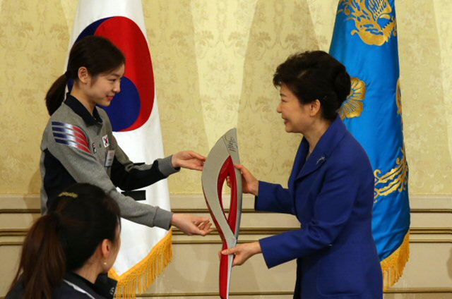 박근혜 대통령이 5일 청와대 영빈관에서 열린 소치 동계올림픽 선수단 초청 오찬에서 김연아로부터 기념품으로 성화봉을 선물받고 있다.