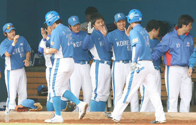 25일 오후 타이완 타이중구장에서 열린 2008 베이징올림픽 야구대표팀과 단국대의 연습경기,  대표팀이 공격에 나선 1회초 1사 만루 상황에서 이대호의 적시타로 이승엽과 고영민이 홈을 밟은 후 팀 동료들과 함께 하이 파이브하고 있다. 